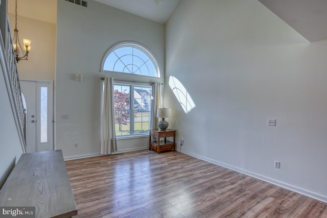 entrance foyer featuring a healthy amount of sunlight, hardwood / wood-style flooring, and high vaulted ceiling