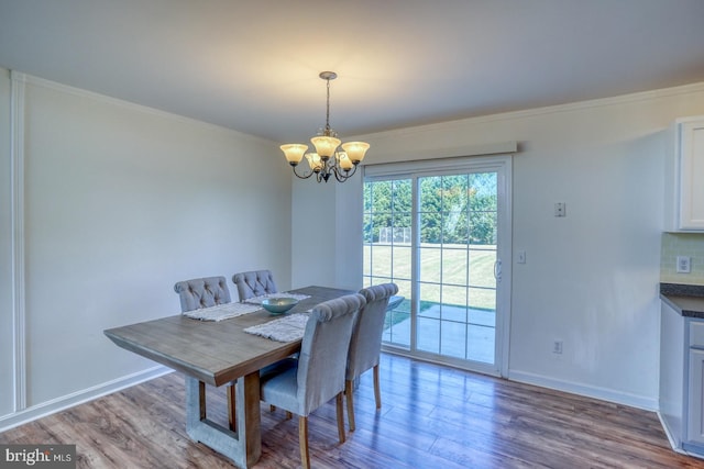 dining area featuring crown molding, hardwood / wood-style flooring, and a notable chandelier