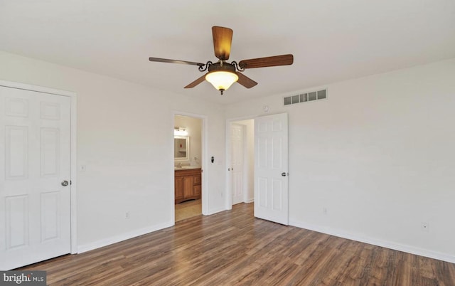 unfurnished bedroom with ceiling fan, dark hardwood / wood-style flooring, and ensuite bath