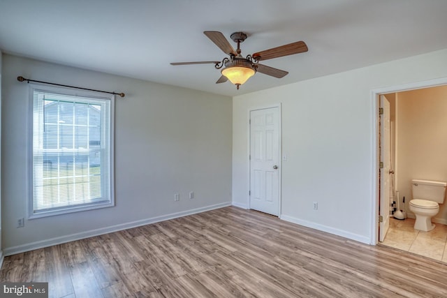 unfurnished bedroom featuring ceiling fan, light hardwood / wood-style floors, and ensuite bath