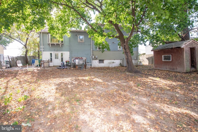 back of house featuring a shed