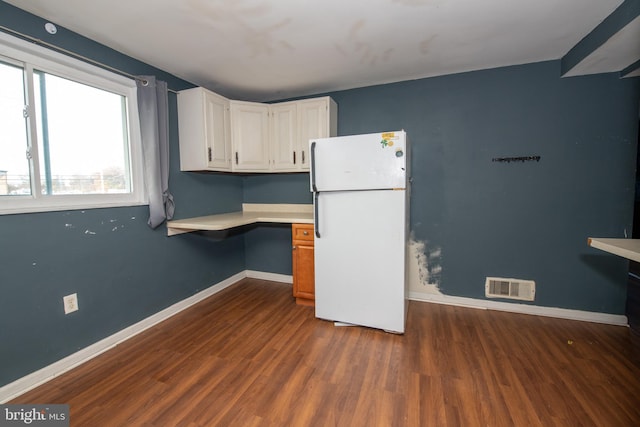 kitchen with built in desk, dark hardwood / wood-style flooring, white refrigerator, and white cabinets