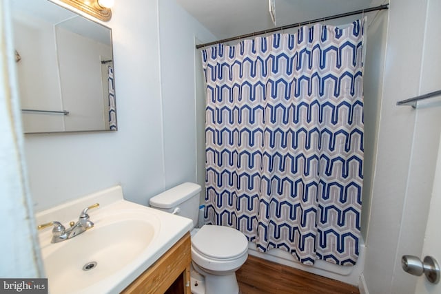 bathroom with toilet, vanity, and wood-type flooring