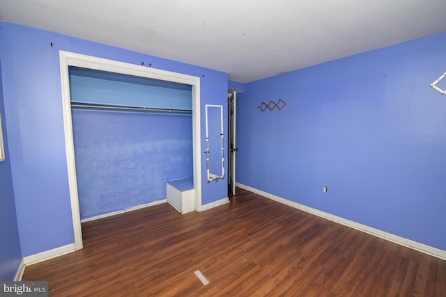 unfurnished bedroom featuring a closet and dark hardwood / wood-style flooring