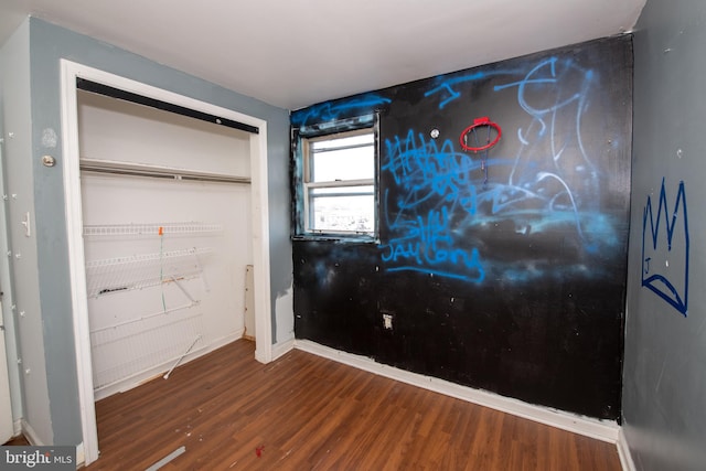 unfurnished bedroom featuring dark wood-type flooring and a closet