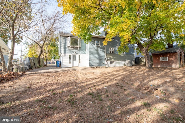 rear view of house with a storage shed