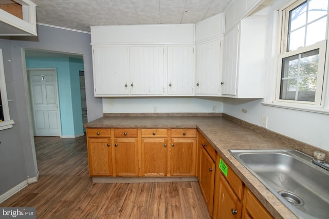 1019 Green Ln, Levittown, PA 19057 - kitchen with a sink, ornamental molding, light wood-type flooring, white cabinetry, and baseboards