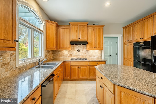 kitchen featuring sink, tasteful backsplash, stainless steel appliances, and light stone counters