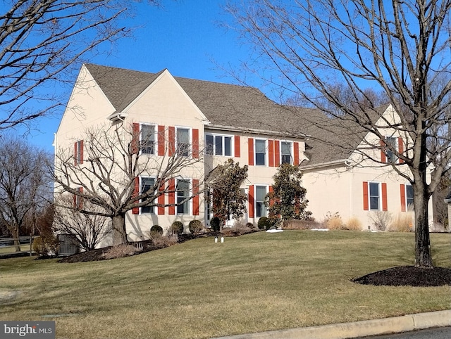 colonial-style house featuring a front lawn