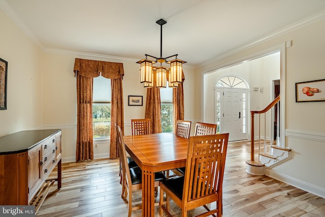 dining space featuring crown molding, a notable chandelier, and light wood-type flooring