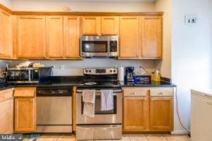 kitchen with appliances with stainless steel finishes and light tile patterned flooring