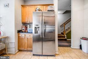 kitchen featuring stainless steel refrigerator with ice dispenser and light tile patterned floors