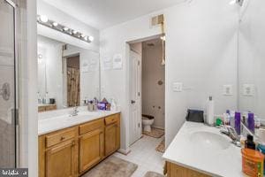 bathroom featuring vanity, toilet, and walk in shower