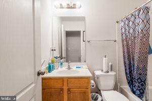 full bathroom with vanity, shower / bath combo with shower curtain, and toilet