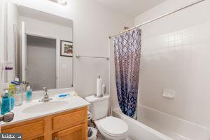 full bathroom with vanity, shower / bath combo, and toilet