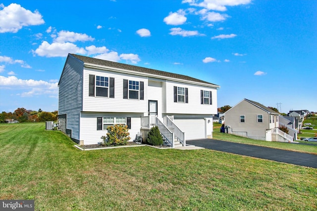 raised ranch with cooling unit, a front lawn, and a garage