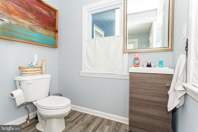 bathroom with toilet, hardwood / wood-style flooring, and vanity