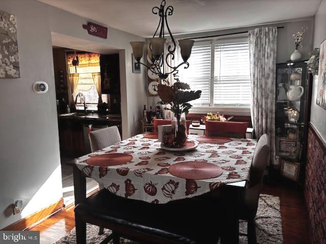 dining space with a notable chandelier, hardwood / wood-style flooring, and sink