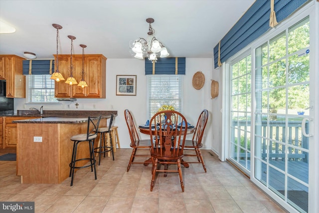 dining space with a notable chandelier, light tile patterned floors, and plenty of natural light