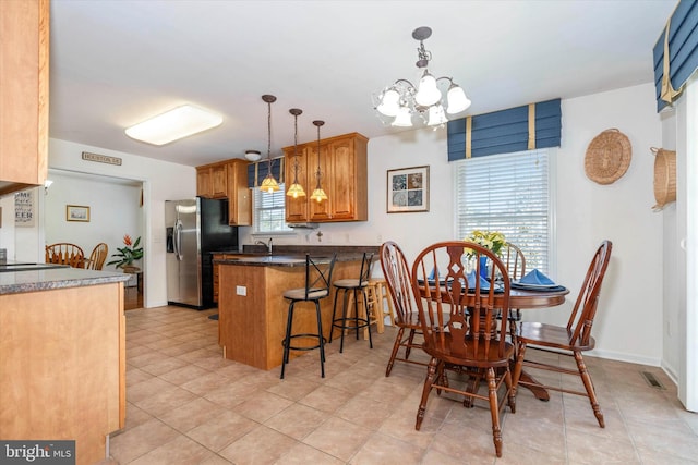 dining area with light tile patterned floors and an inviting chandelier