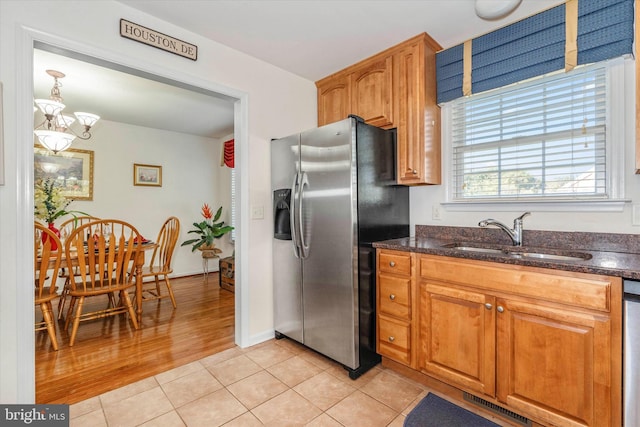 kitchen featuring light hardwood / wood-style flooring, hanging light fixtures, sink, stainless steel fridge with ice dispenser, and an inviting chandelier