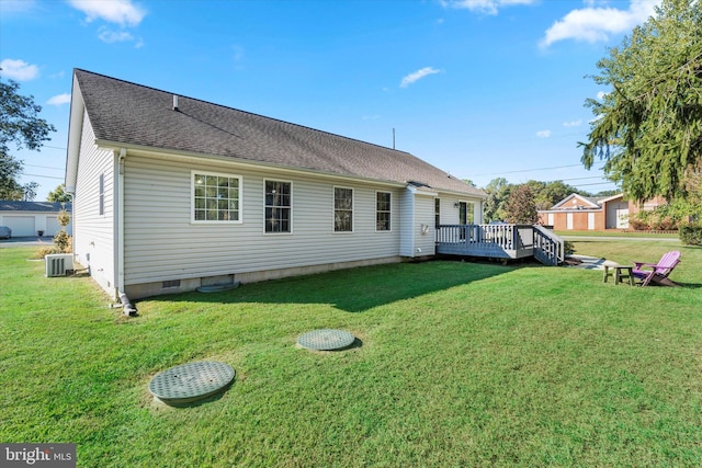 back of house featuring a deck, a lawn, and central AC unit