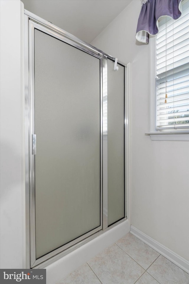 bathroom featuring tile patterned flooring and an enclosed shower