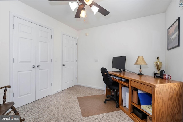 carpeted office space featuring ceiling fan