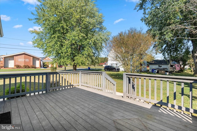 deck with a yard and an outdoor structure