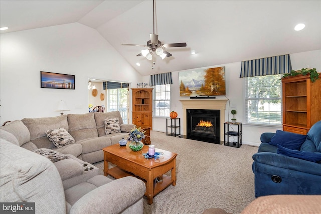 living room with a wealth of natural light, lofted ceiling, carpet flooring, and ceiling fan