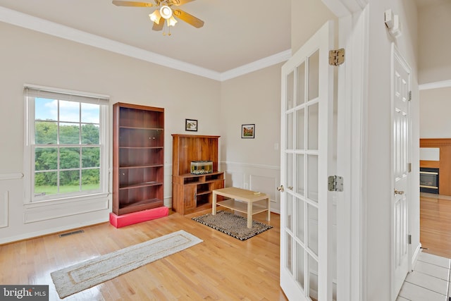 interior space featuring light hardwood / wood-style flooring, ornamental molding, and ceiling fan