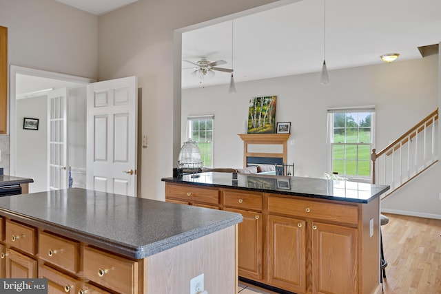 kitchen featuring pendant lighting, light wood-type flooring, a center island, and plenty of natural light