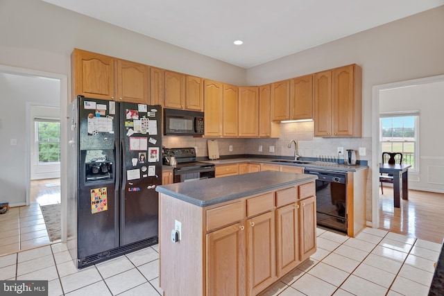 kitchen featuring decorative backsplash, black appliances, sink, and a kitchen island