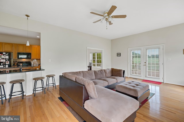 living room featuring light hardwood / wood-style floors, french doors, and ceiling fan