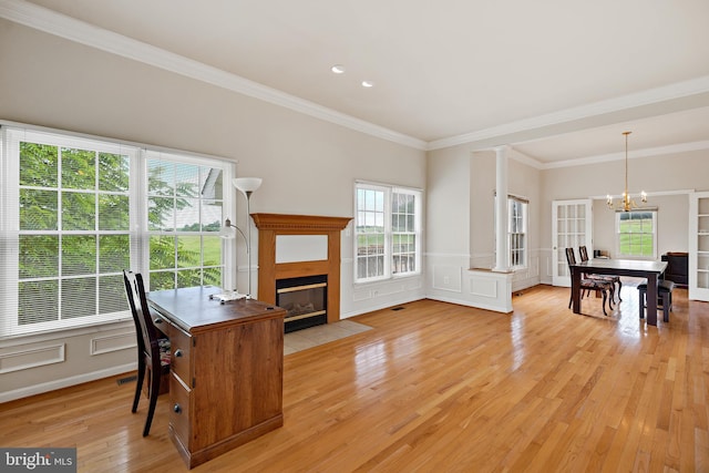 office area with decorative columns, light hardwood / wood-style flooring, an inviting chandelier, and ornamental molding