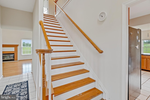 stairway featuring tile patterned floors and plenty of natural light