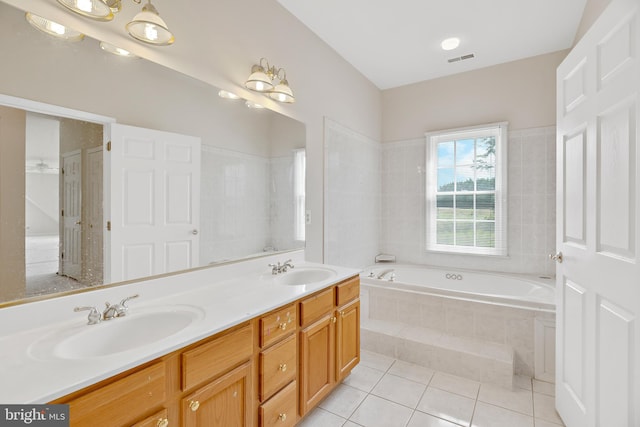 bathroom with vanity, a notable chandelier, tiled tub, and tile patterned floors