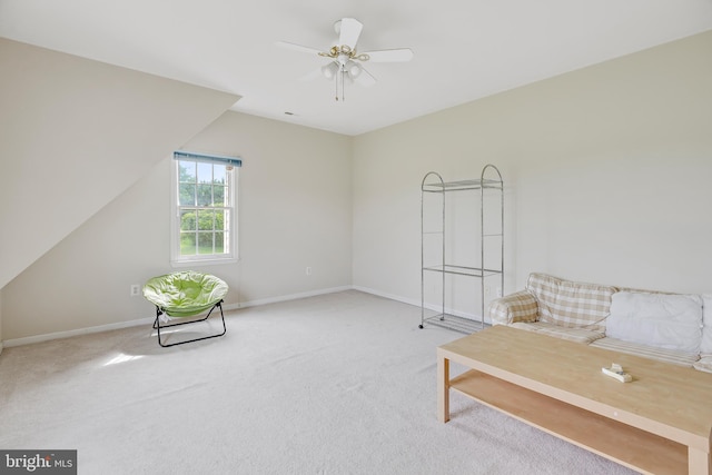 sitting room with ceiling fan and carpet