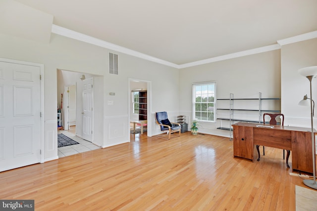 home office featuring light hardwood / wood-style flooring and crown molding