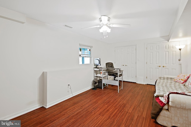 home office with ceiling fan and dark hardwood / wood-style flooring