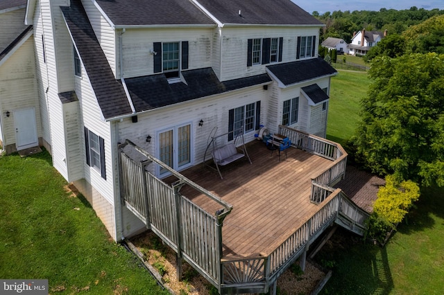 rear view of house with a deck and a lawn