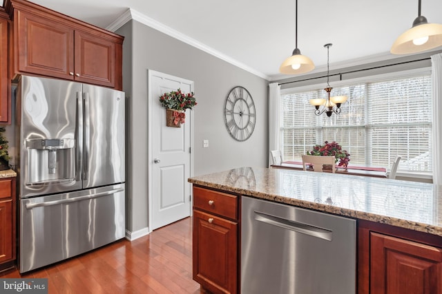 kitchen with dark hardwood / wood-style floors, light stone countertops, stainless steel appliances, and ornamental molding