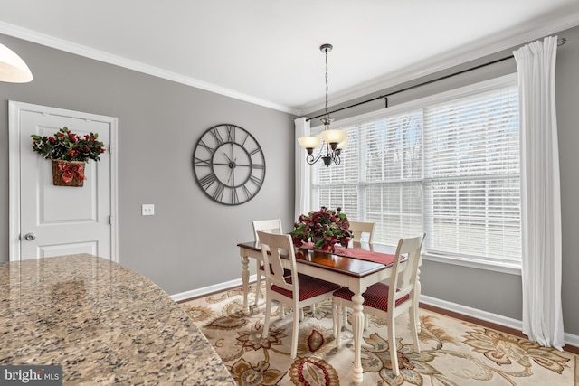 dining room featuring light hardwood / wood-style floors, crown molding, and a notable chandelier