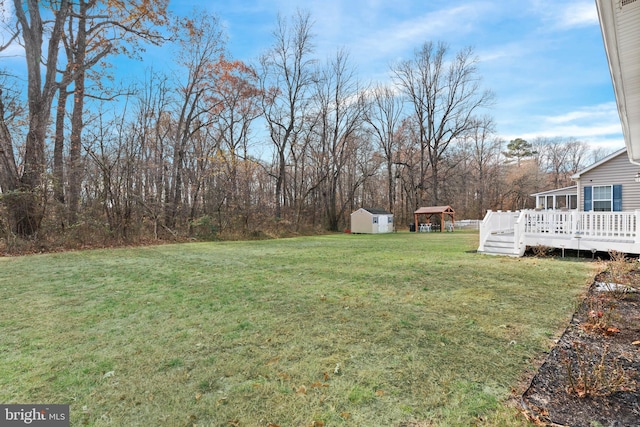 view of yard featuring a shed and a wooden deck