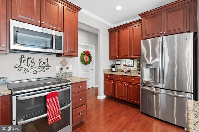 kitchen with light stone countertops, appliances with stainless steel finishes, ornamental molding, and dark wood-type flooring