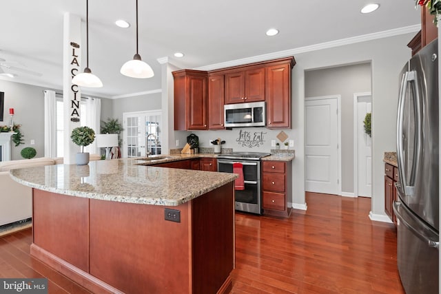 kitchen featuring sink, stainless steel appliances, dark hardwood / wood-style floors, kitchen peninsula, and decorative light fixtures