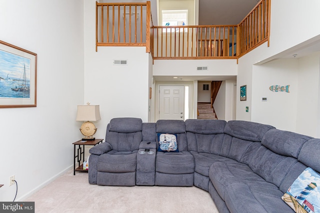 carpeted living room with a towering ceiling