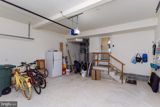 garage with a garage door opener and white refrigerator