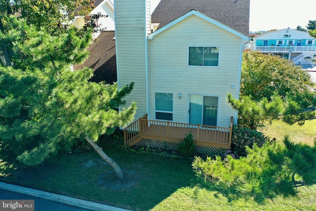 rear view of house with a deck and a lawn