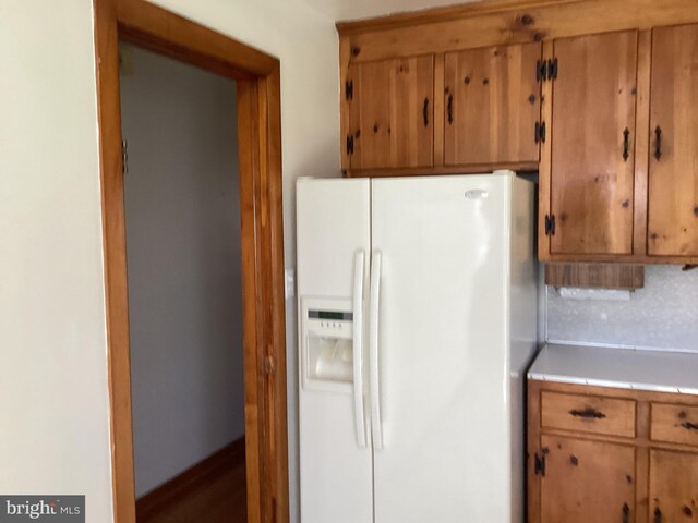 17604 Woodlawn Dr, Hagerstown, MD 21740 - kitchen featuring tile counters, white fridge with ice dispenser, and brown cabinetry